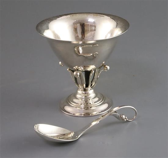 A Georg Jensen planished silver sugar bowl with everted rim on pierced foliate pedestal and circular foot and a matching spoon,